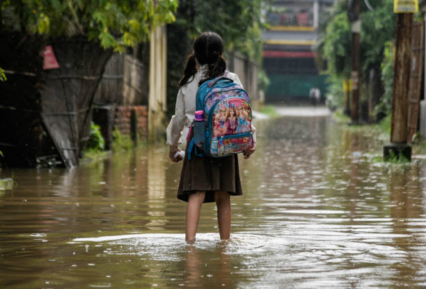 Girl walking in floodwaters in India