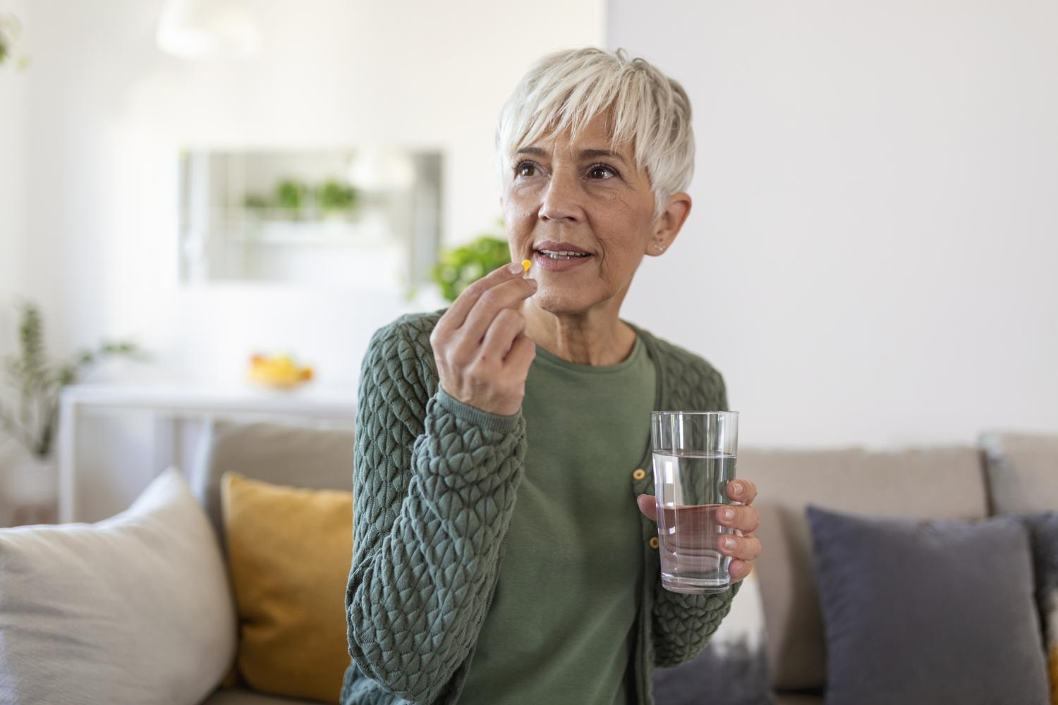 Older woman taking pill