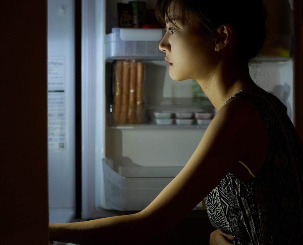 Girl staring into fridge