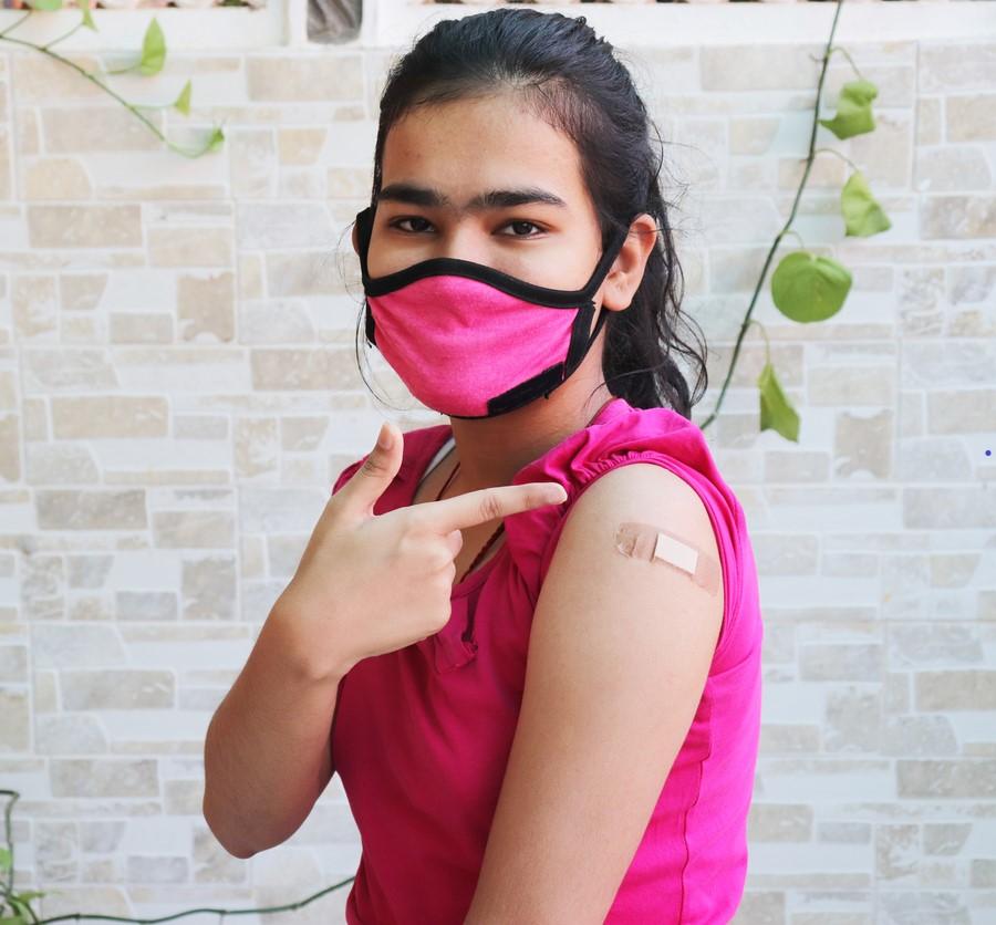 Teen girl showing off post-vaccine bandage