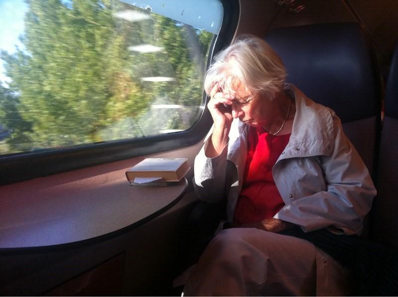 Tired older woman at train window