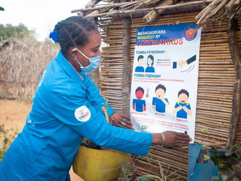 Woman posting COVID poster in Africa