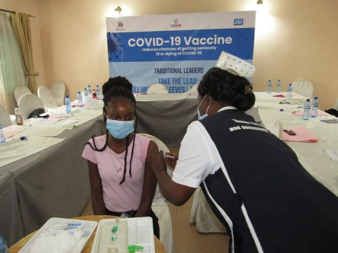 Nurse vaccinating girl in Africa