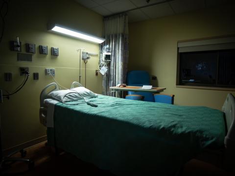 Empty bed in dark hospital room