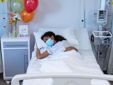 Girl wearing mask in hospital bed