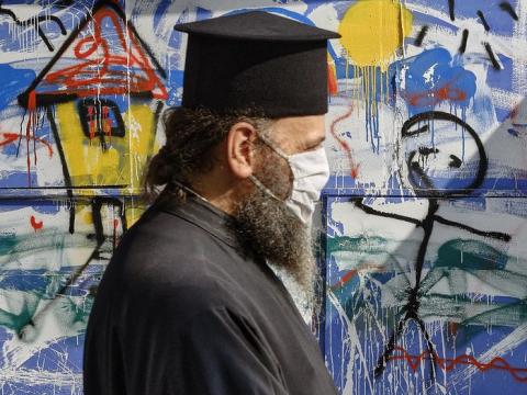 Greek Orthodox priest wearing mask in Athens