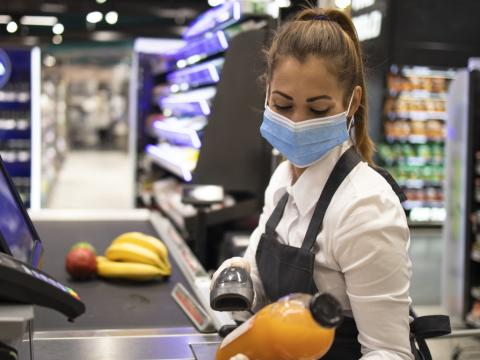 Grocery store cashier wearing mask