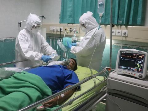 Nurses giving oxygen to ICU patient