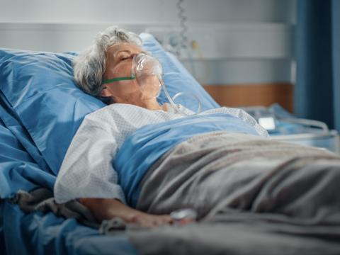 Older woman in hospital bed on oxygen