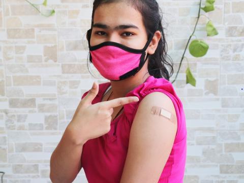 Teen girl showing off post-vaccine bandage