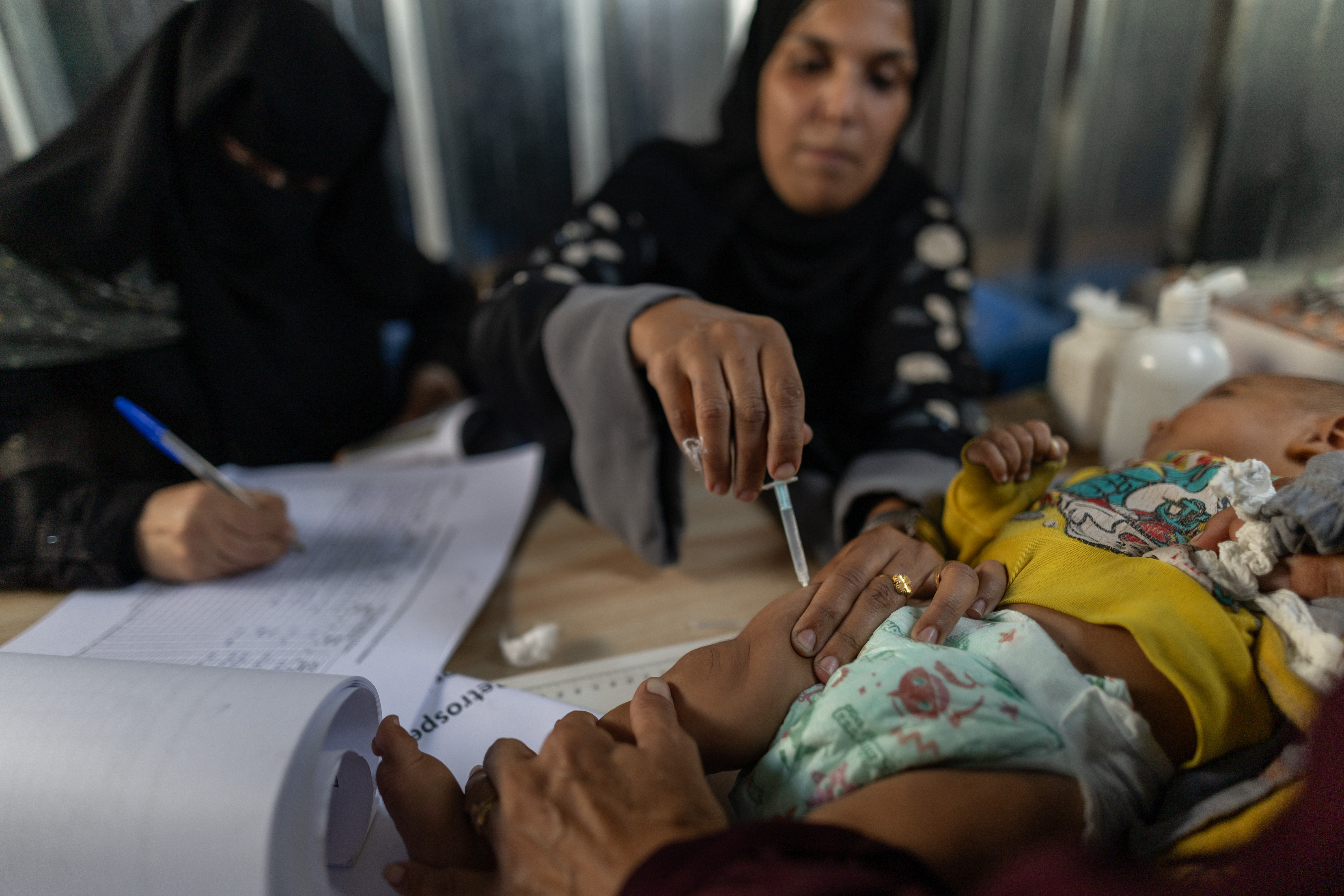 Woman vaccinating child in Ghaza