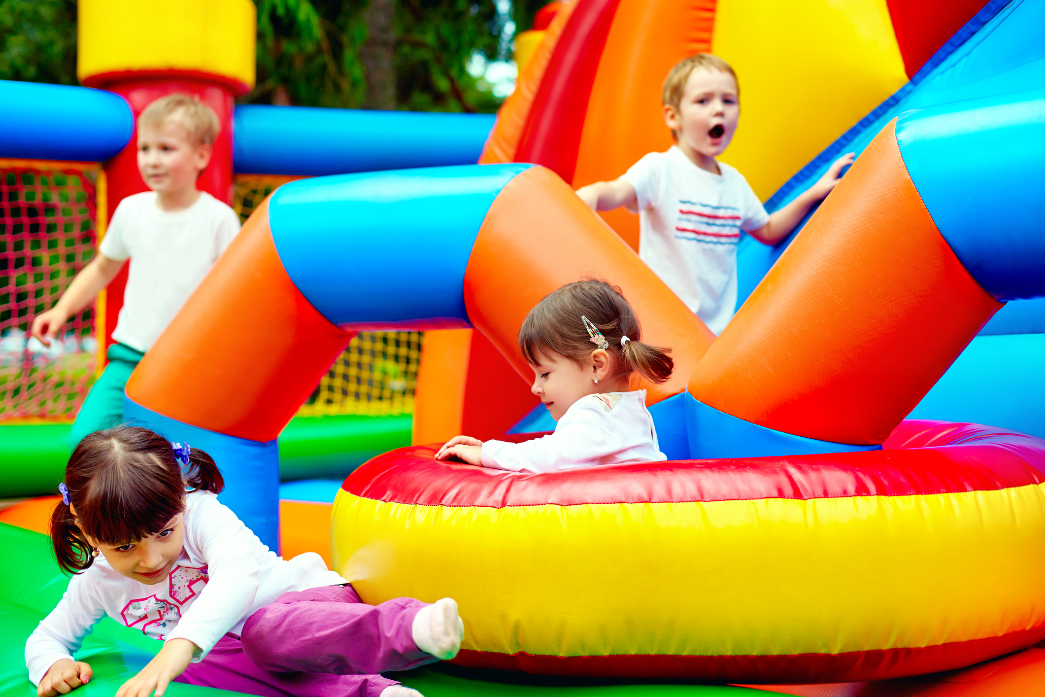 Young boys and girls on a multicolored bouncy castle