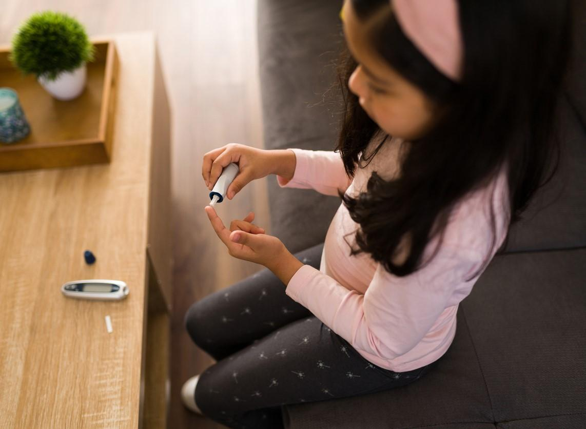 Girl checking blood glucose