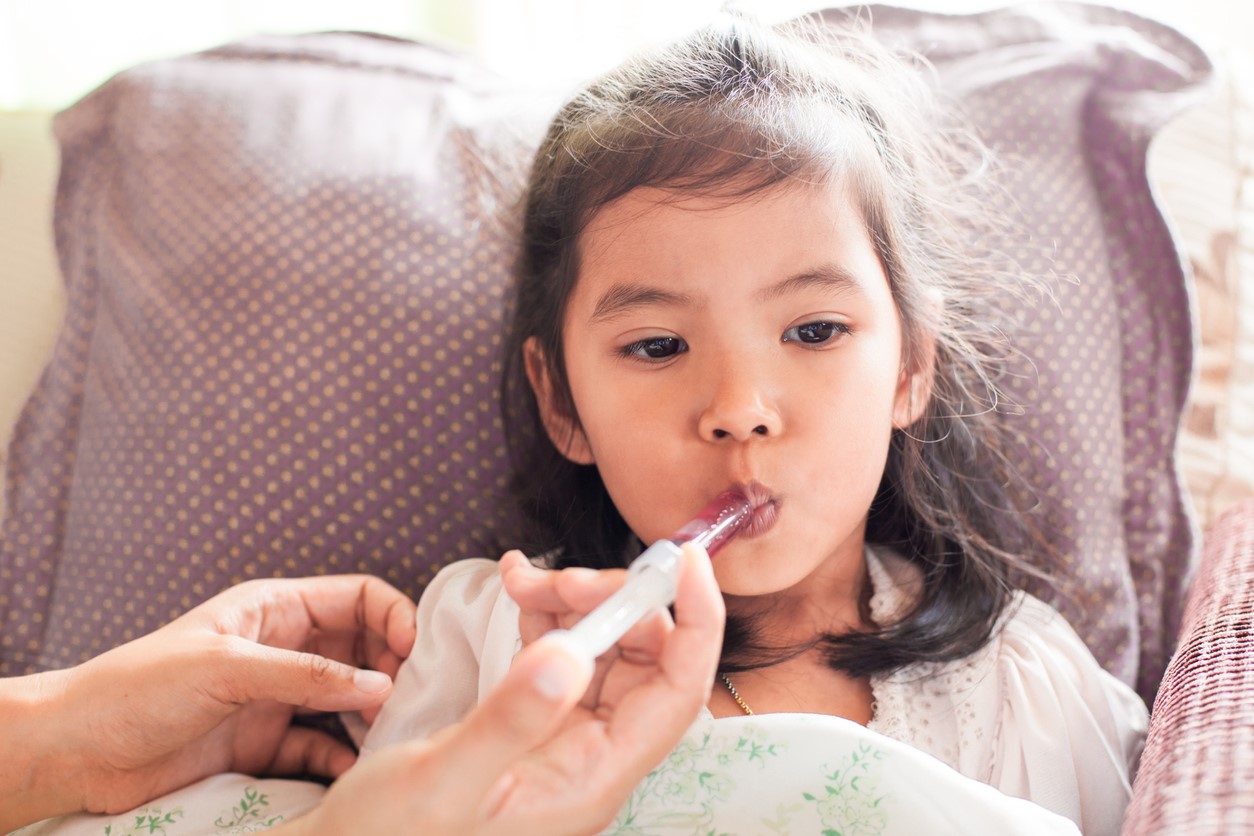 Girl receiving liquid medicine