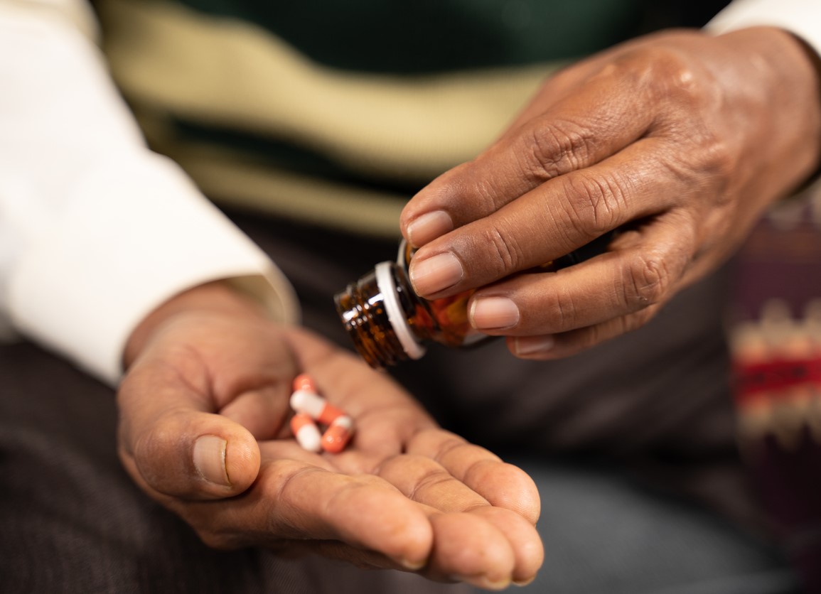 hands of elderly man taking pills