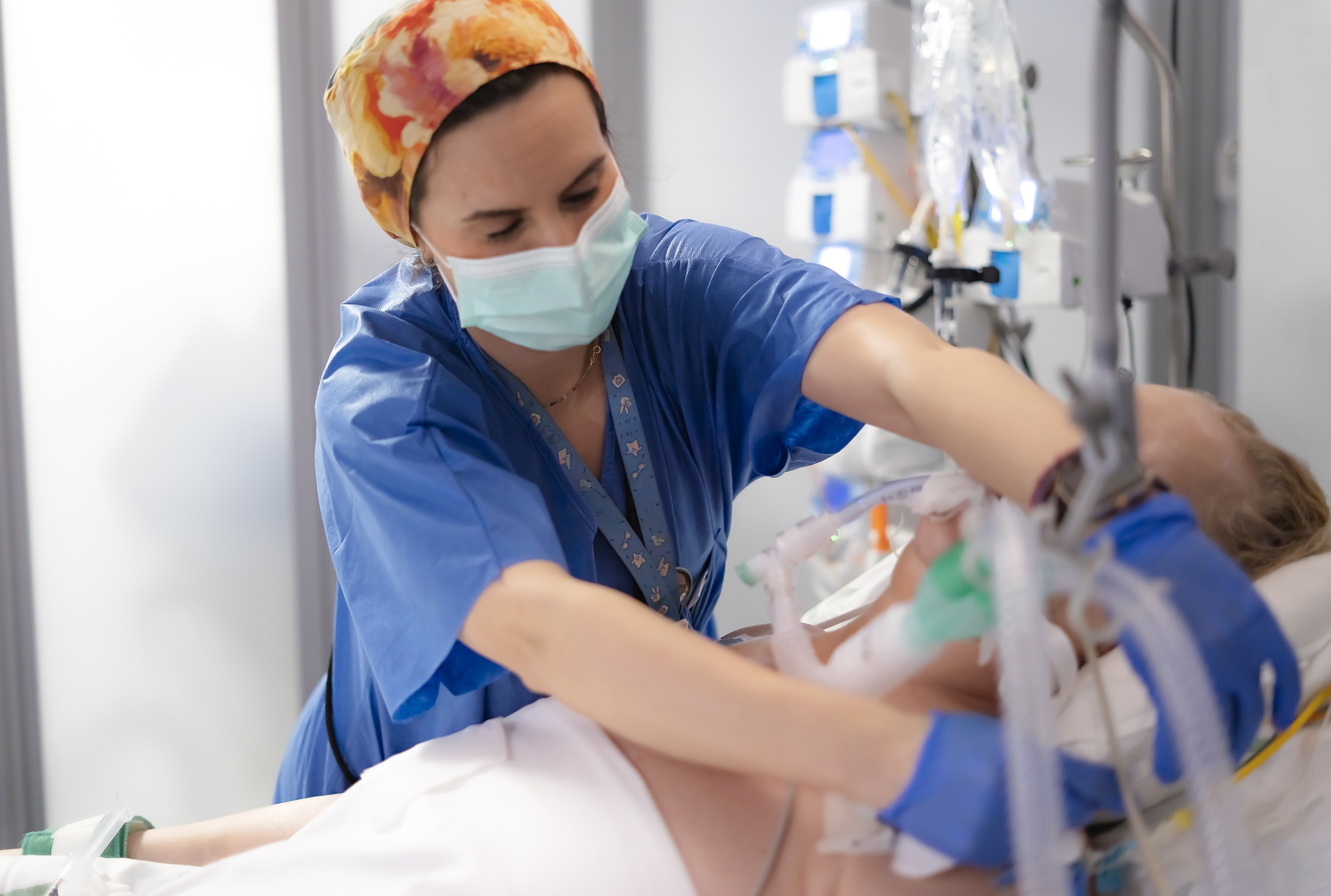 Nurse adjusting the ventilator of an ICU patient