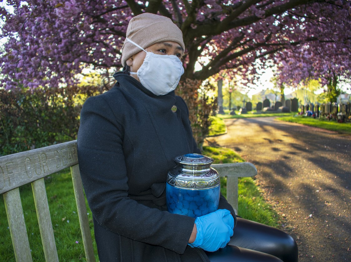 Person with urn in cemetary