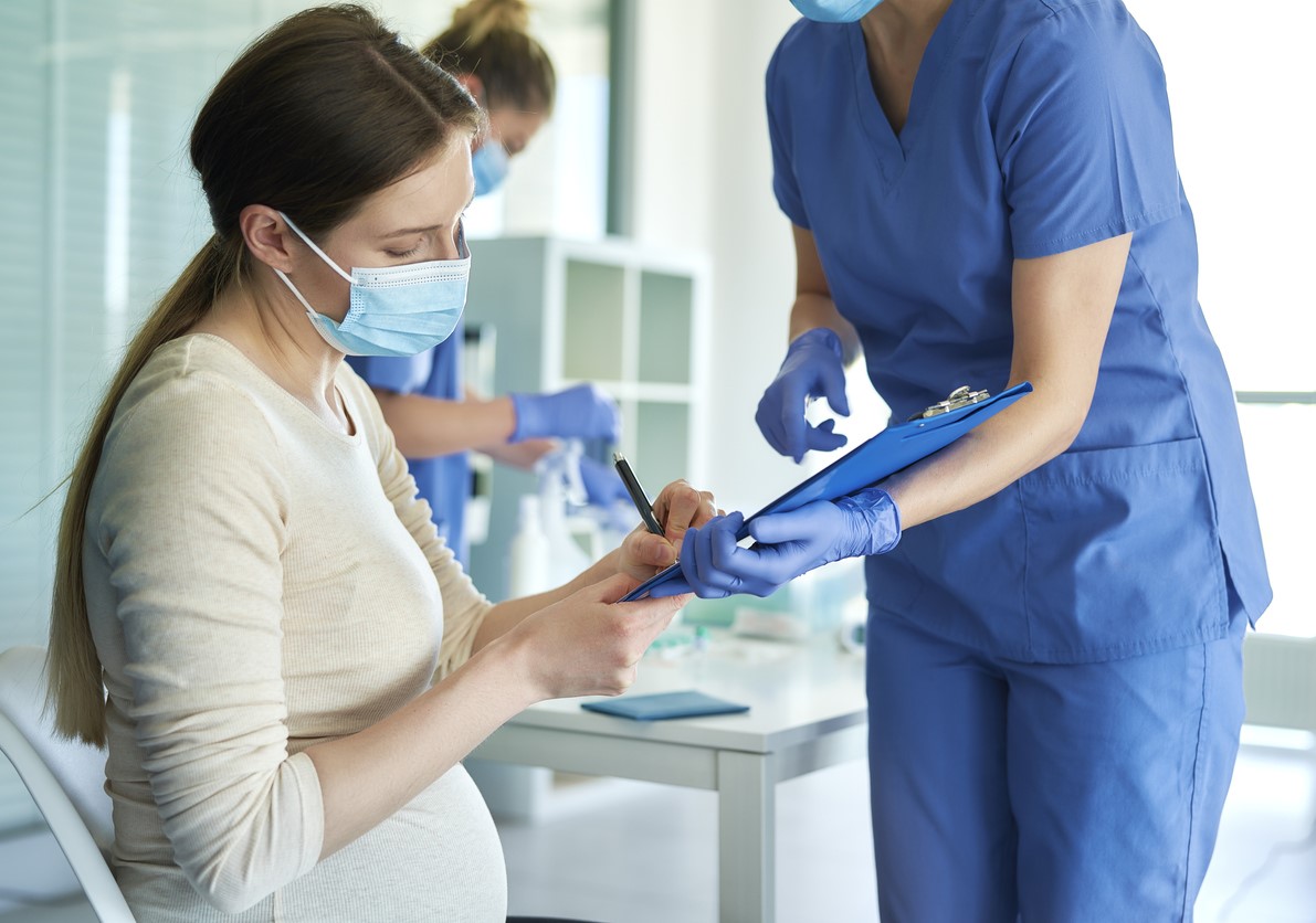 Pregnant woman signing vaccine paperwork