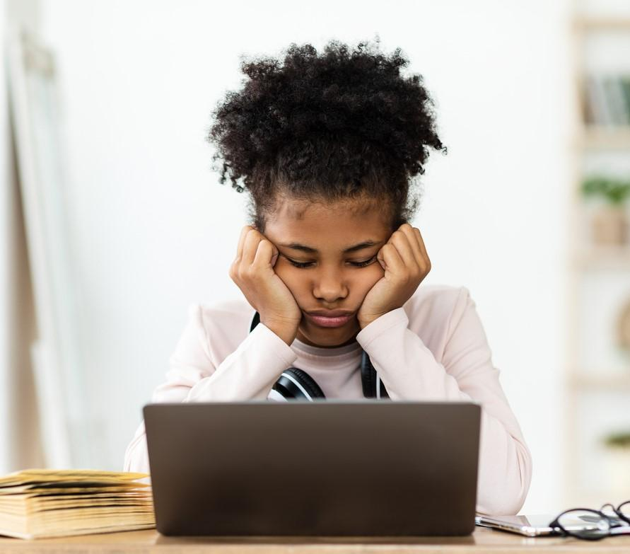 Sad young boy looking at laptop