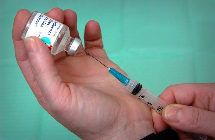 Syringe in flu vaccine vial