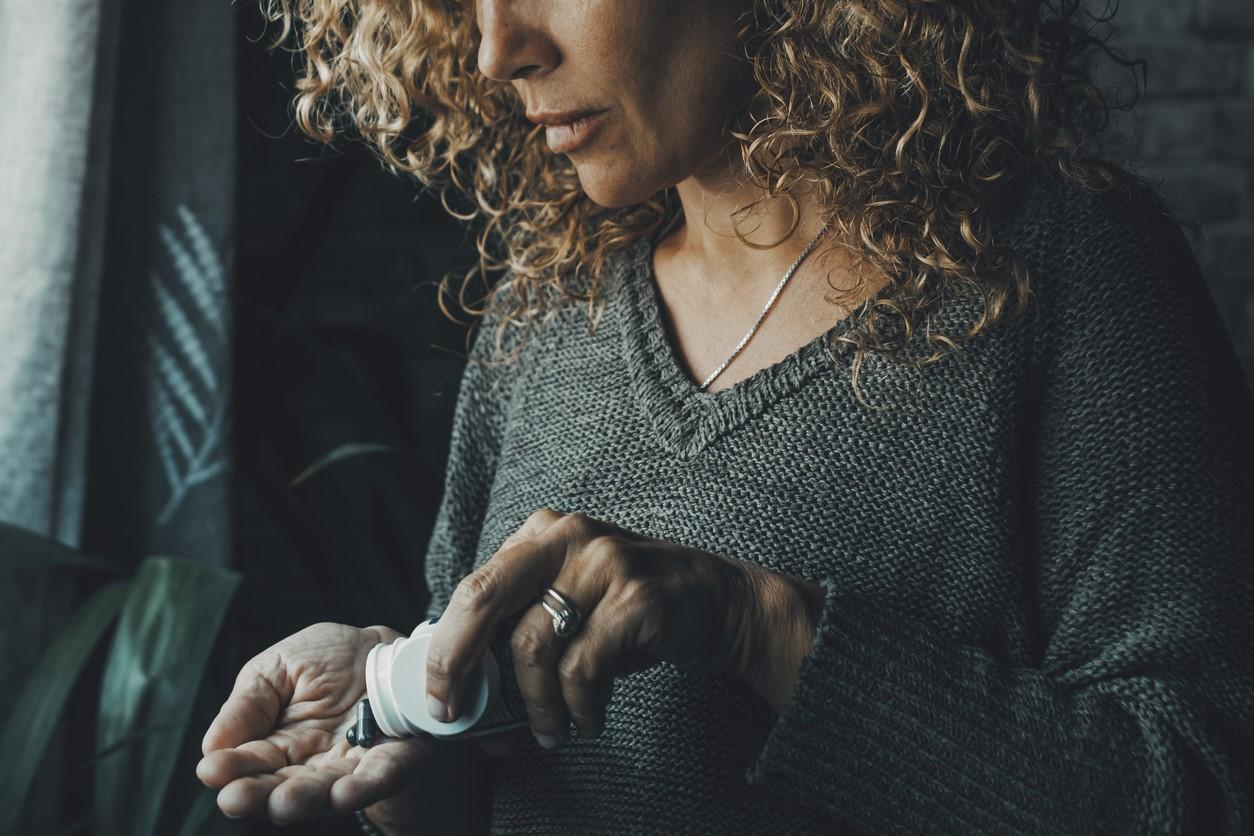 Woman taking pill from hand