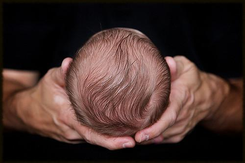 Man's hands holding baby