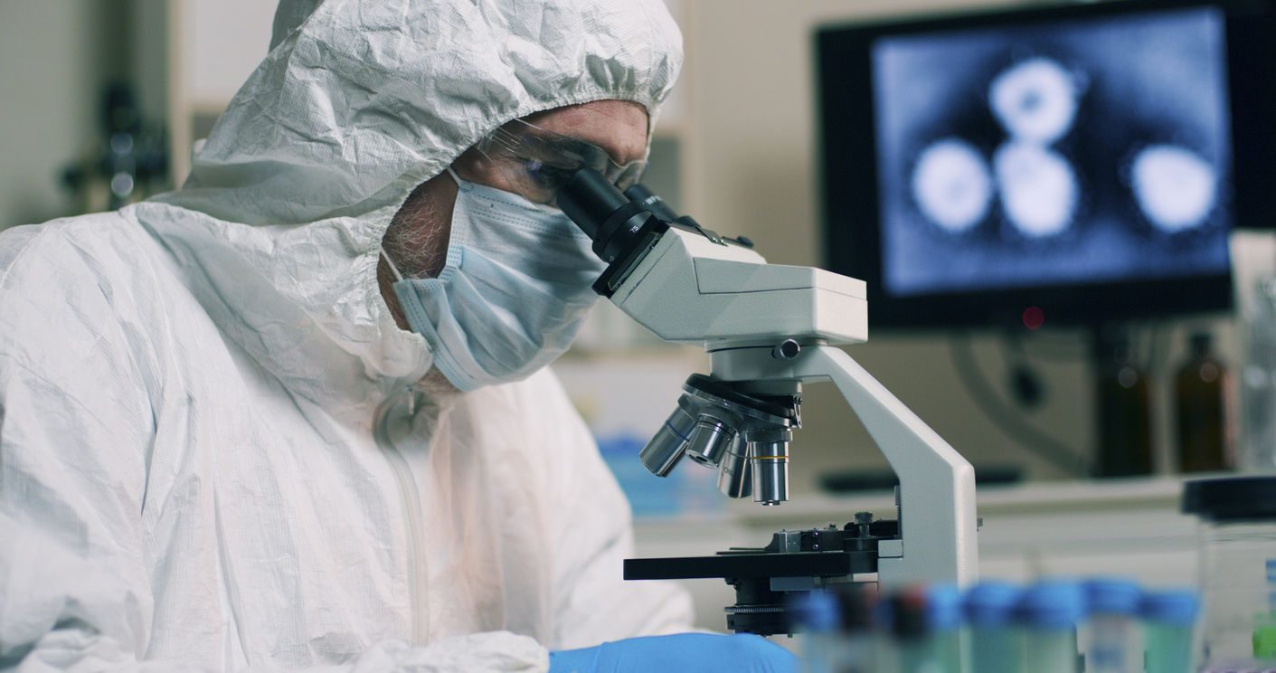 Scientist looking through microscope
