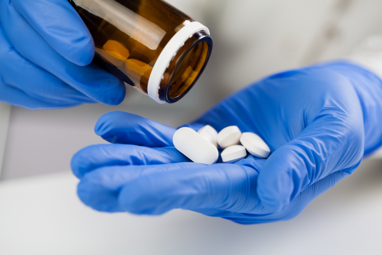 Gloved hand with pills