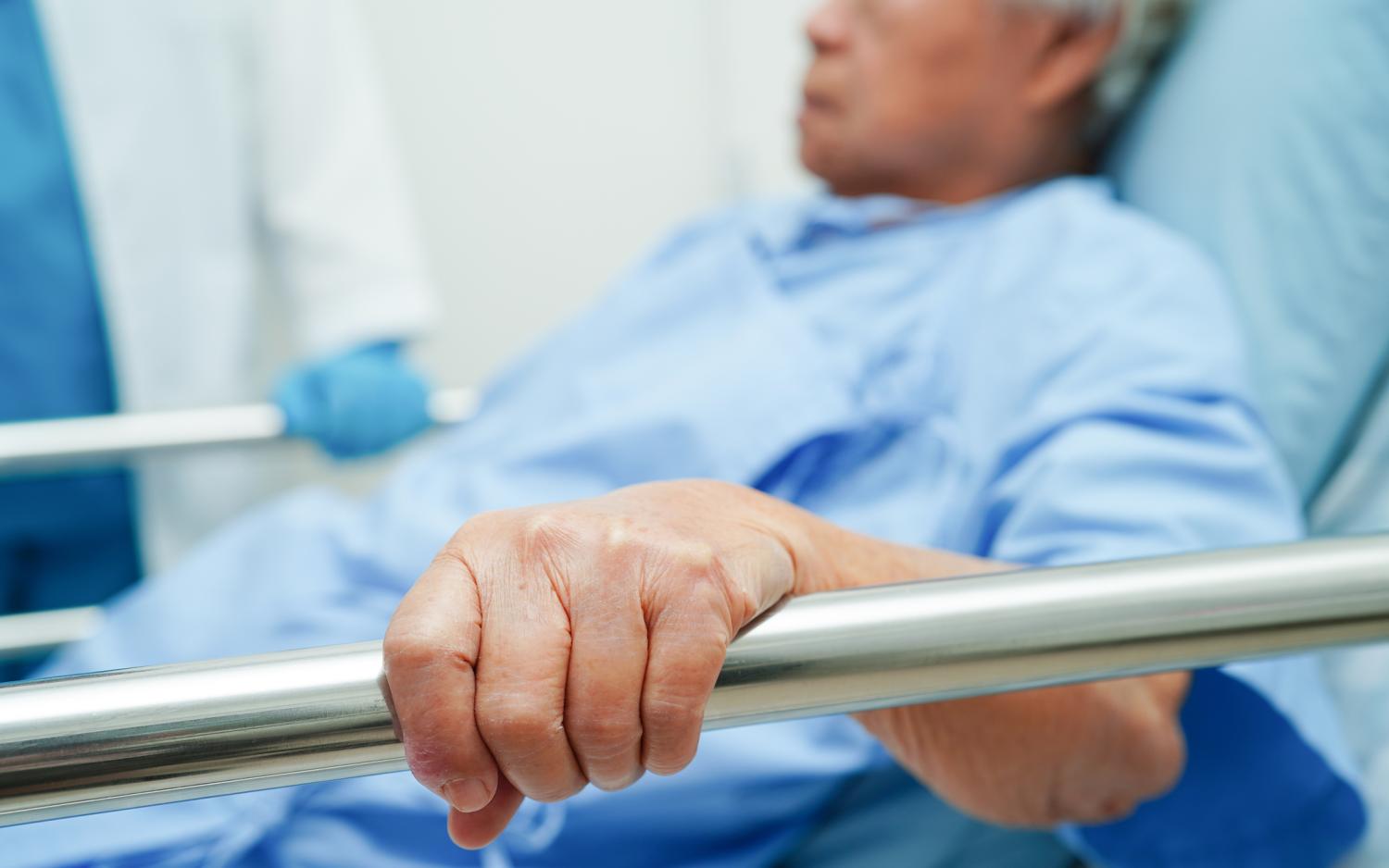 Patient holding hospital bed rail