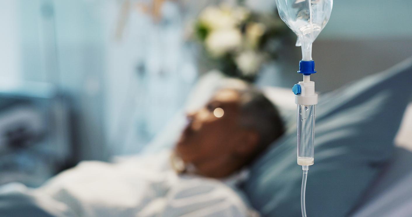 Blurry picture of a patient in hospital bed with IV drip in the foreground