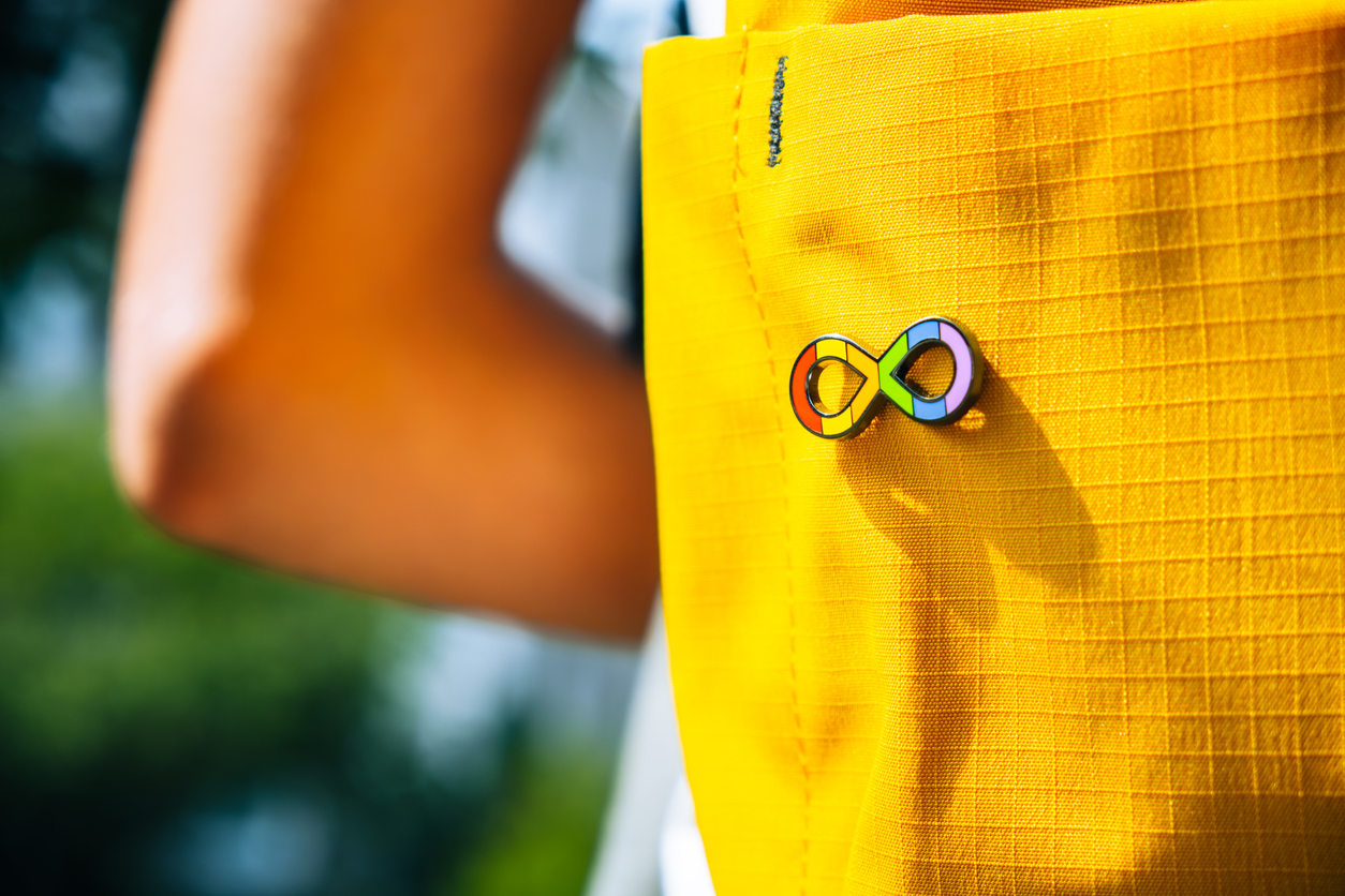 Rainbow autism pin on yellow backpack