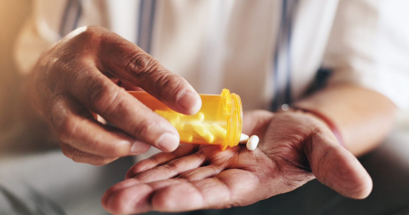 Hand with bottle of pills