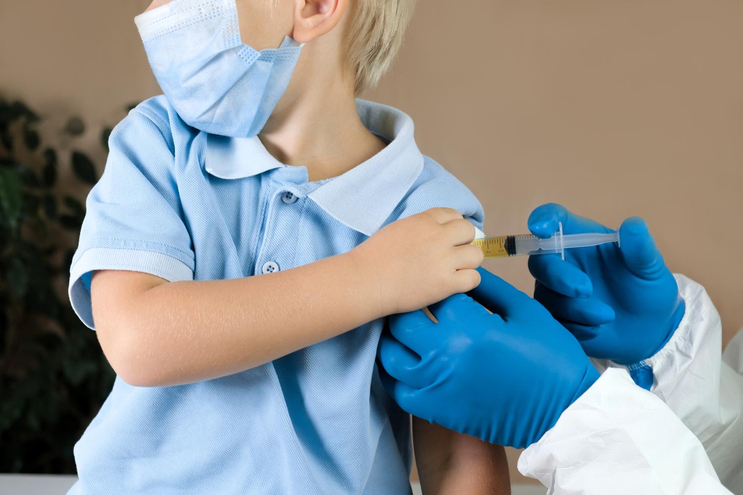 Boy in blue shirt getting vaccinated