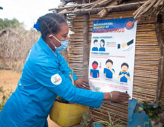 Woman posting COVID poster in Africa