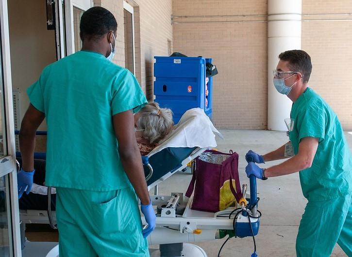 Nurses rolling patient into hospital amid COVID