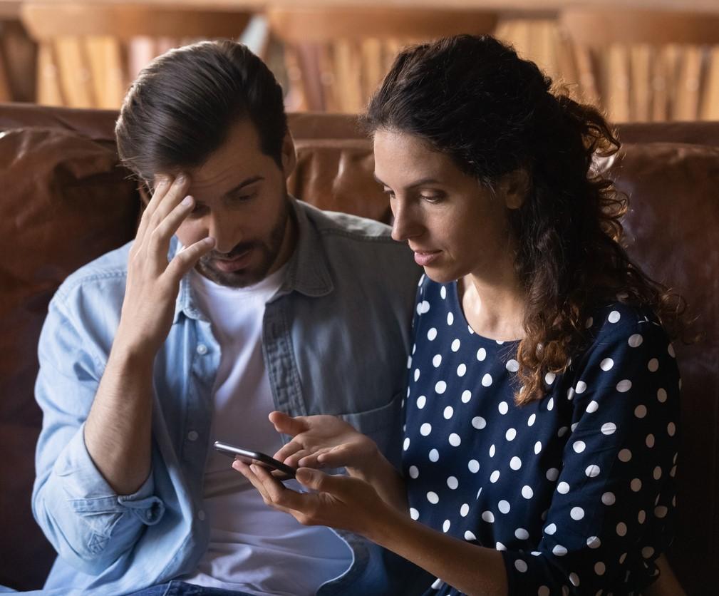 Confused couple viewing smartphone