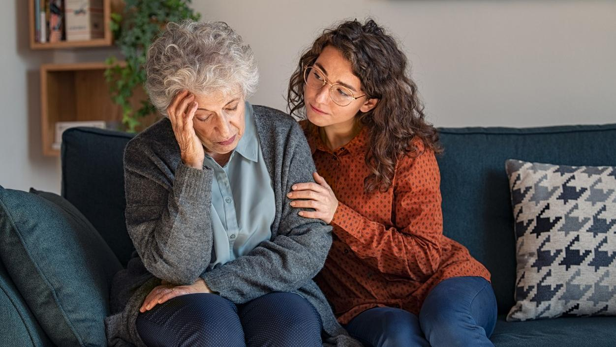 Daughter comforting confused mother