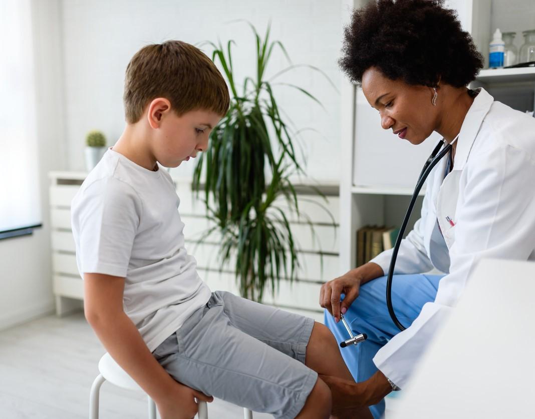 Doctor testing child's reflexes