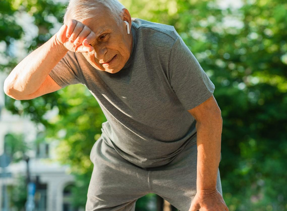 Older man wiping brow