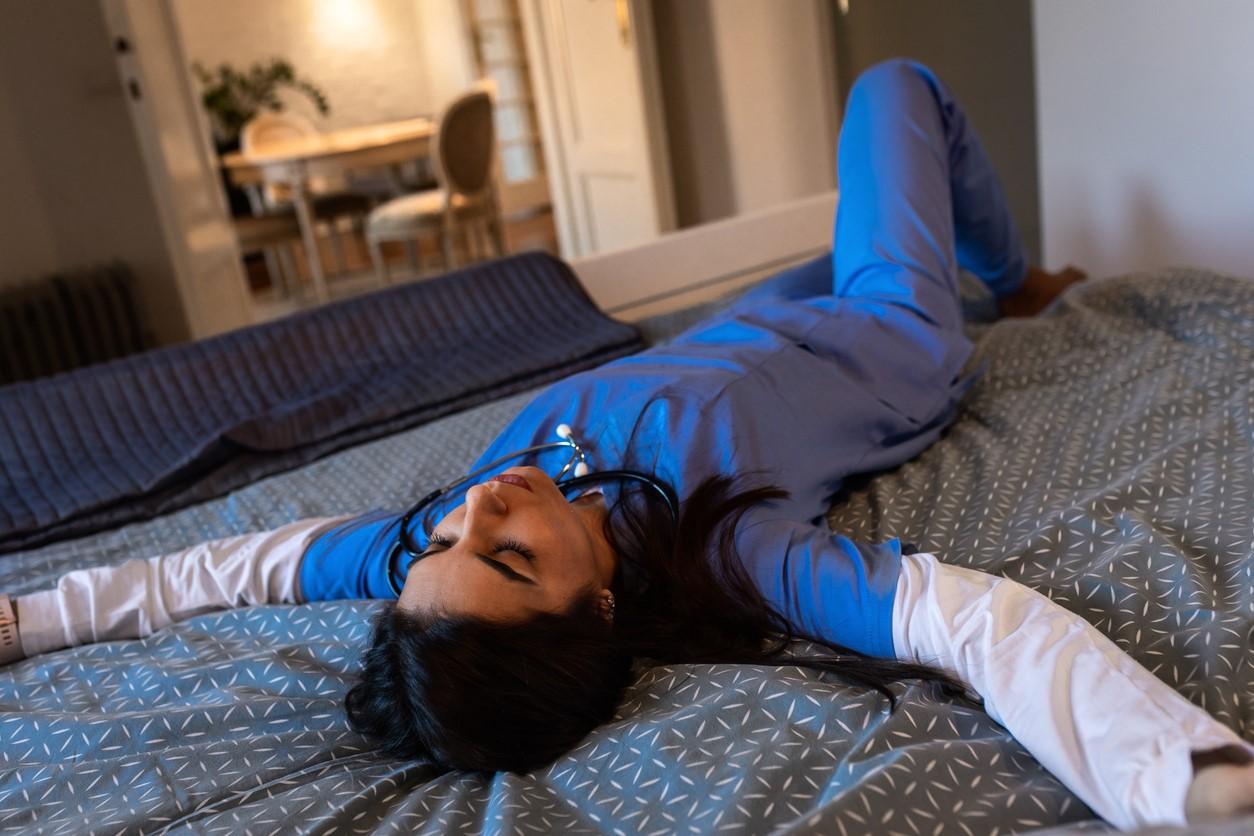 Exhausted nurse on bed