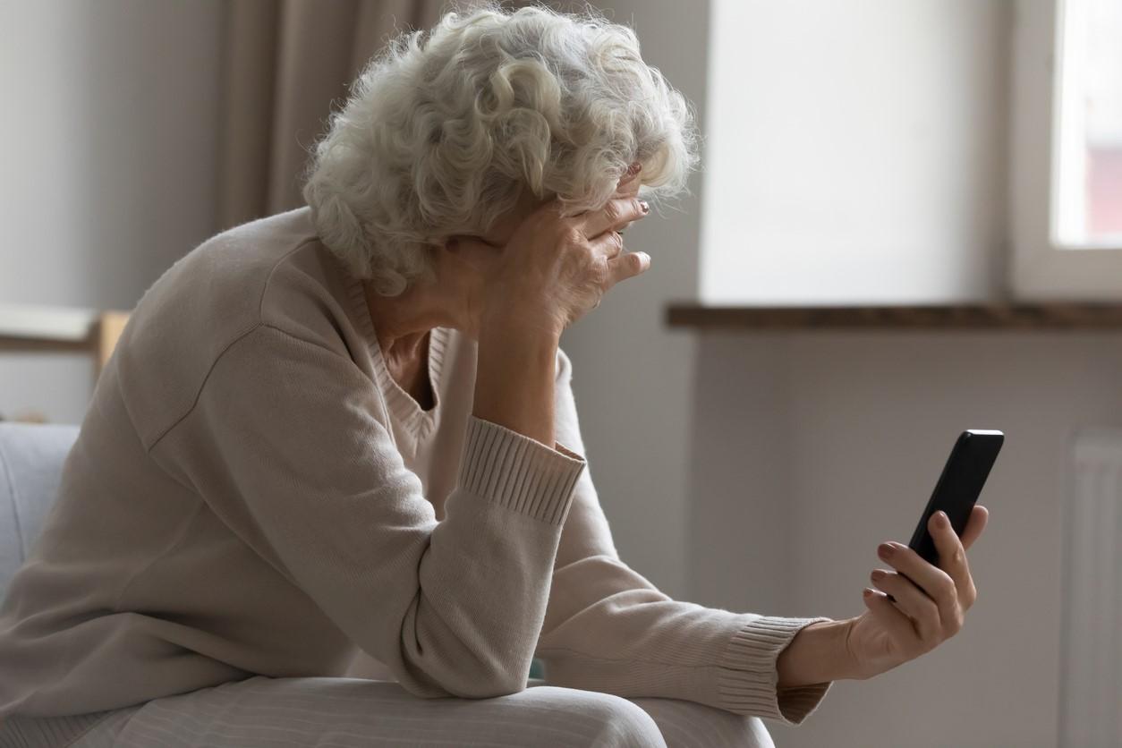 Frustrated elderly woman on smartphone