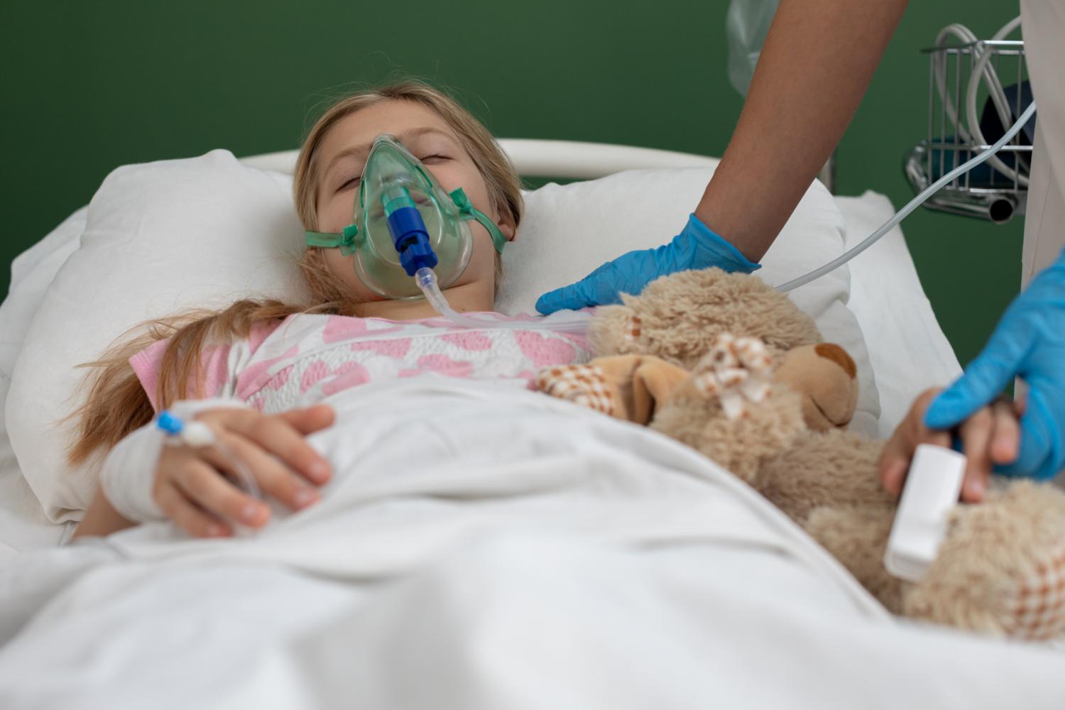Girl with oxygen mask and teddy bear