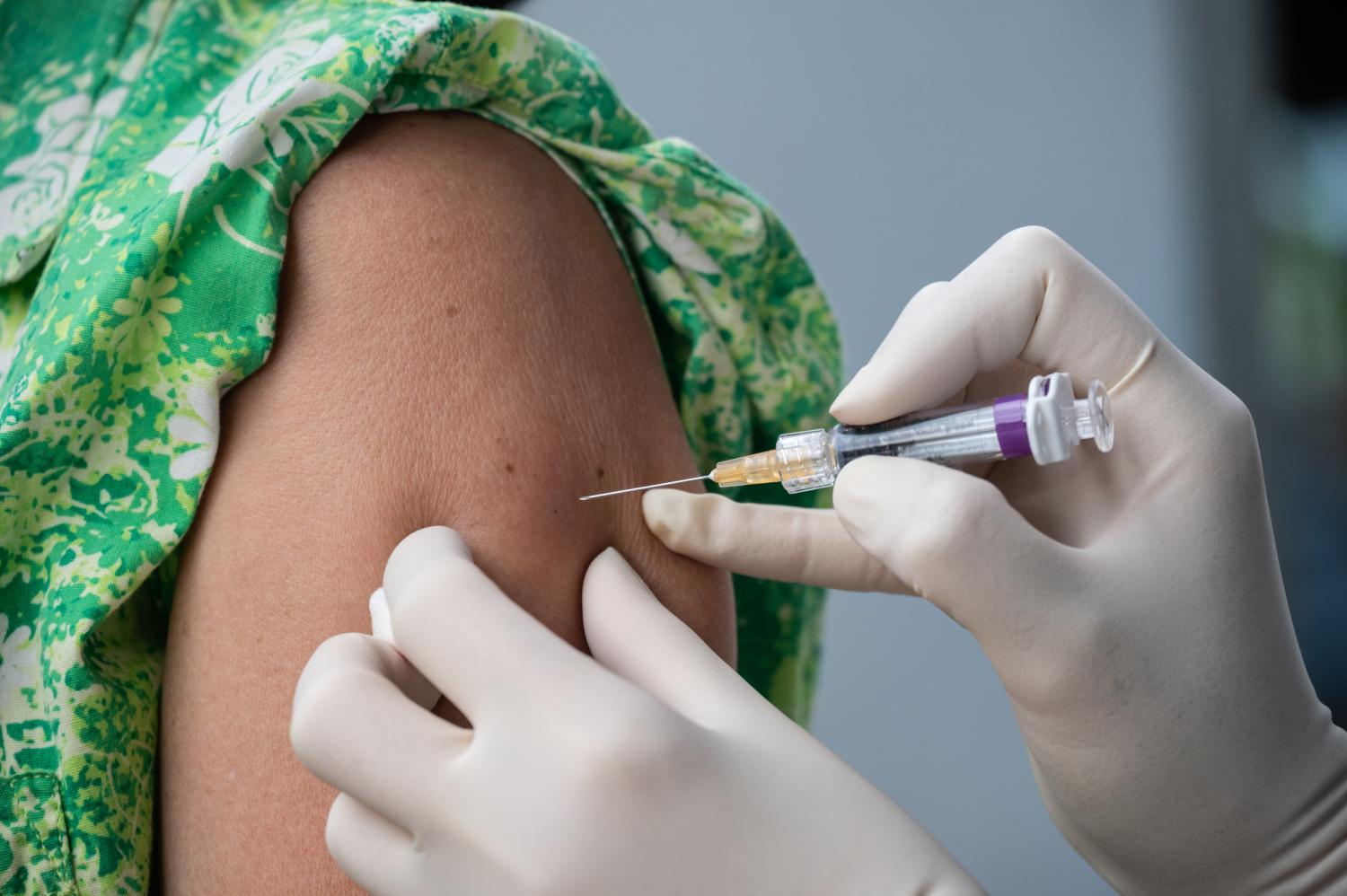 Girl in green dress being vaccinated