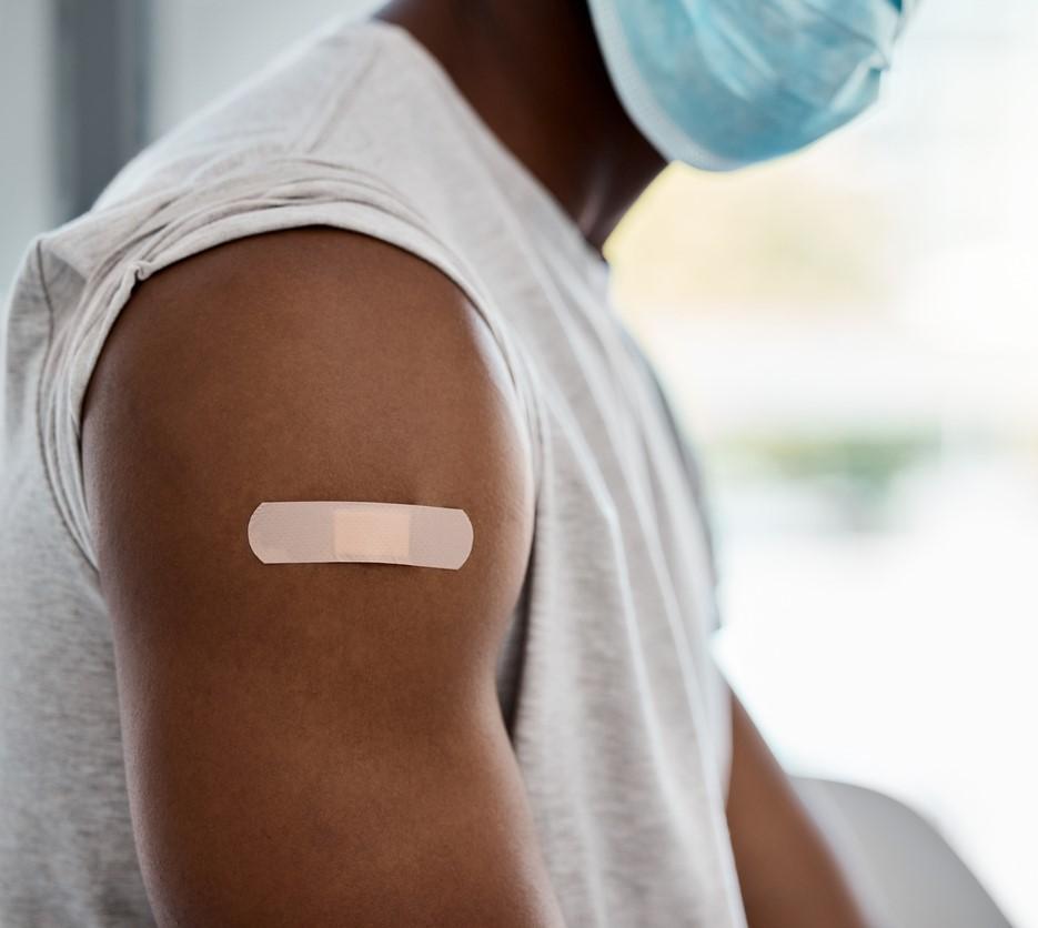 Mans arm with vax bandaid