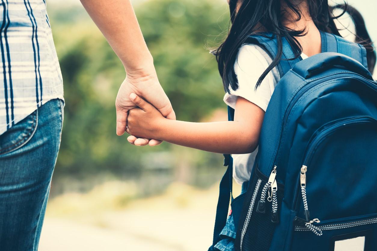 Mom and schoolgirl holding hands