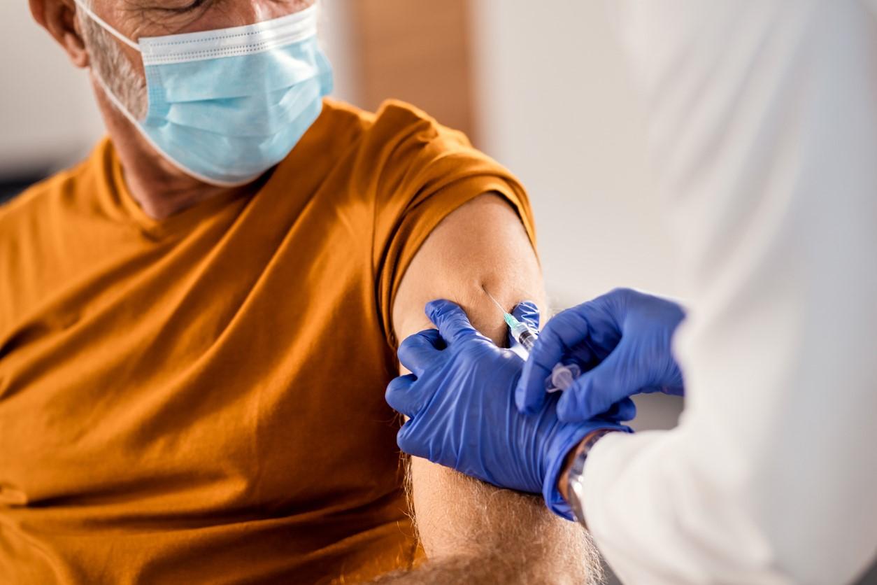 Older man getting vaccine in arm