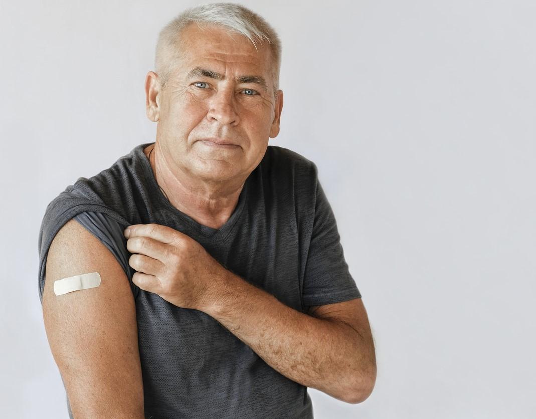 Older man with vaccine band-aid
