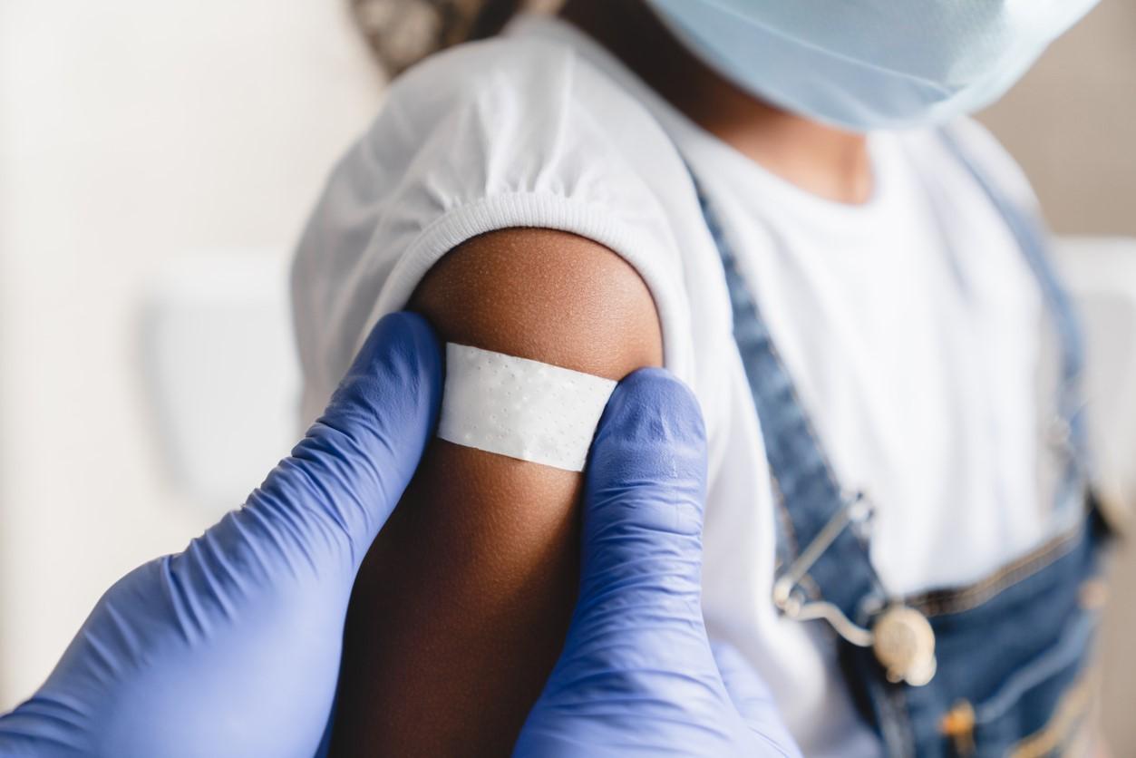 Little girl with post-vaccination bandage on arm