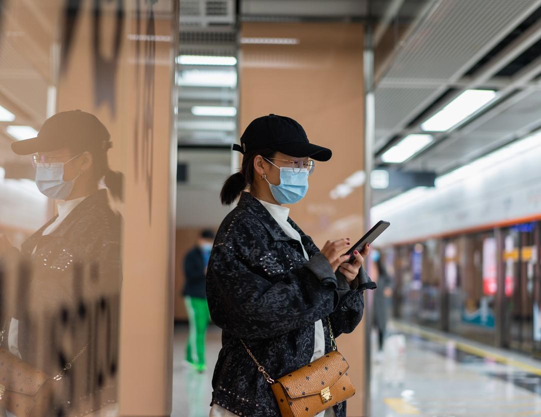 Woman in mask waiting for subway train