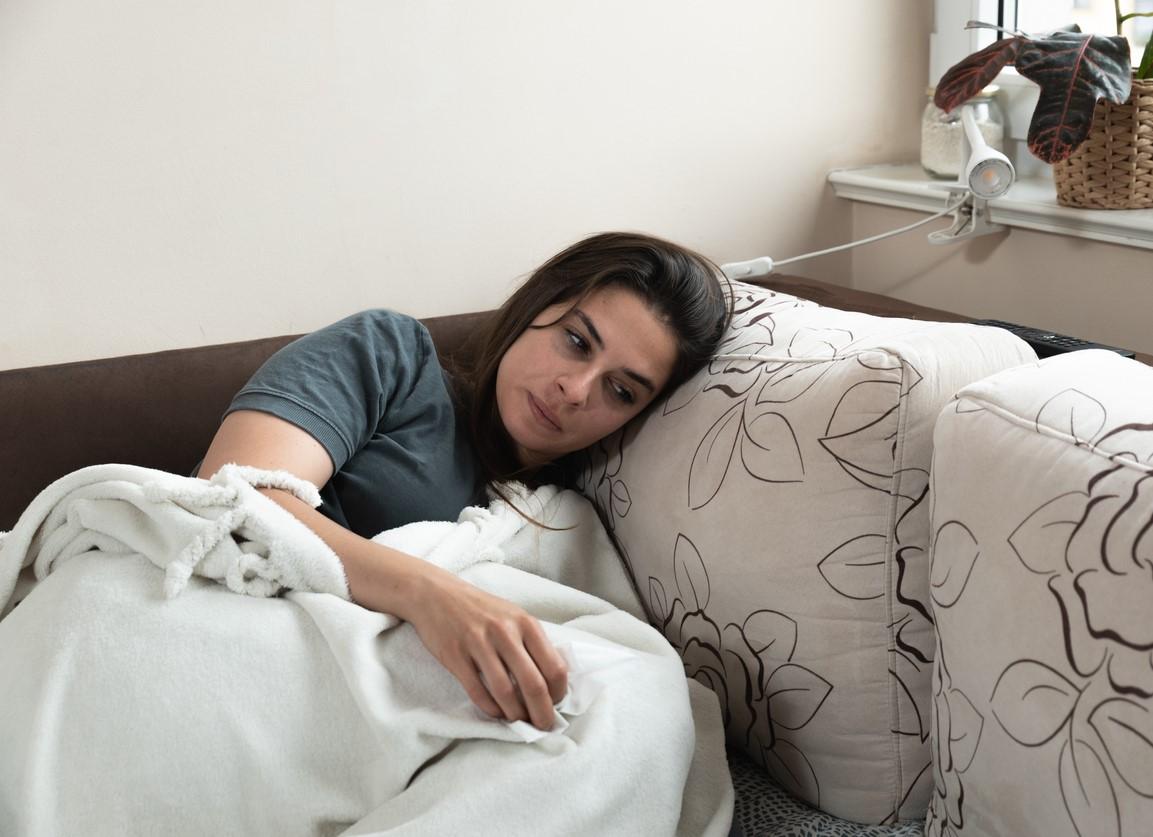 Sick woman lying on day bed